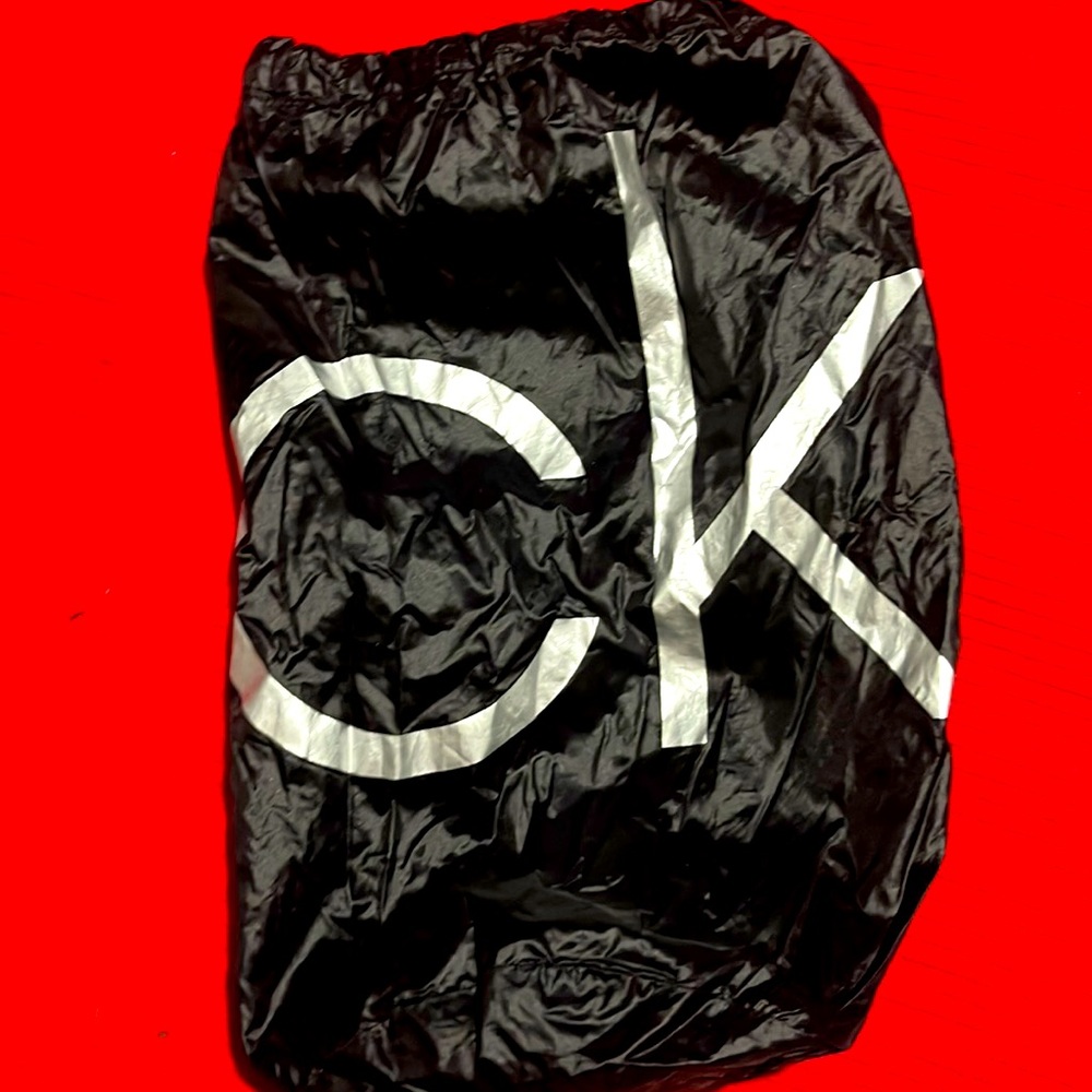 CK black draw string bag, used but great condition. Black and silver 12” x 5”